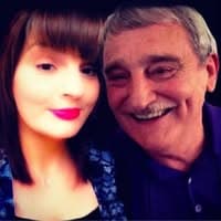Close-up of a smiling young woman and an older man with grey hair and mustache.